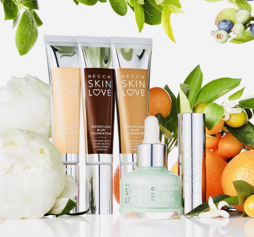 La gamma di prodotti Becca Skin Love per la cura del viso, lo skin love glow elixir, diverse tonalità di fondotinta weightless blur foundation, e il glow glaze Stock