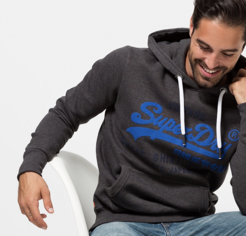 Modello che indossa felpa grigio scuro della Superdry con logo in blu